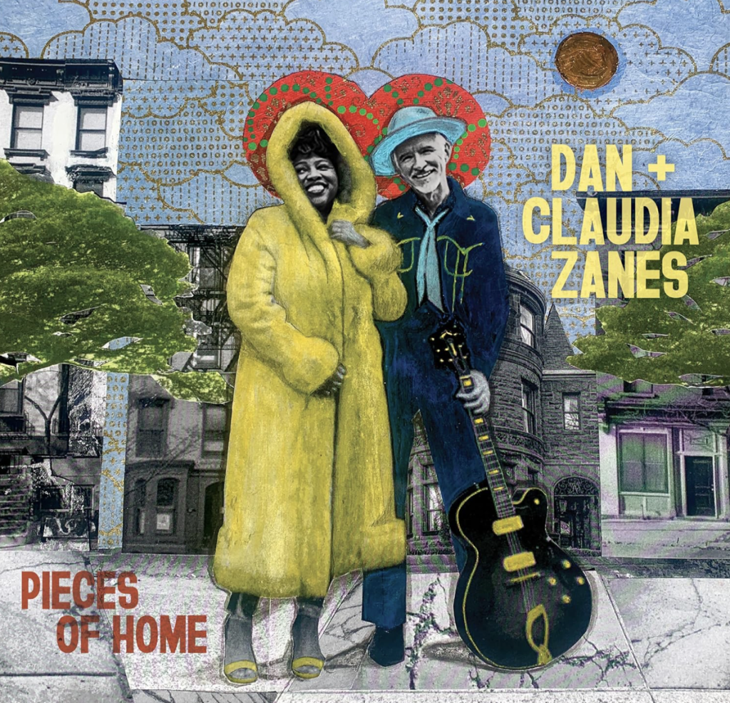 This is the cover art of our new album, Pieces of Home. Claudia is wearing a full length yellow coat and Dan is holding a guitar wearing a black cowboy outfit and a blue hat.